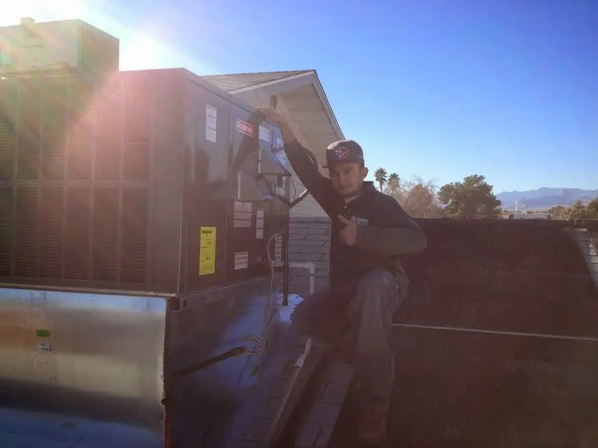 HVAC technician performing Air Duct Cleaning on a rooftop unit in Monfort Heights